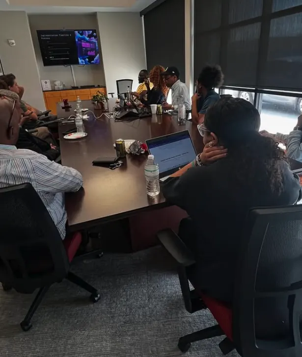 A full conference room watching a presentation on a screen